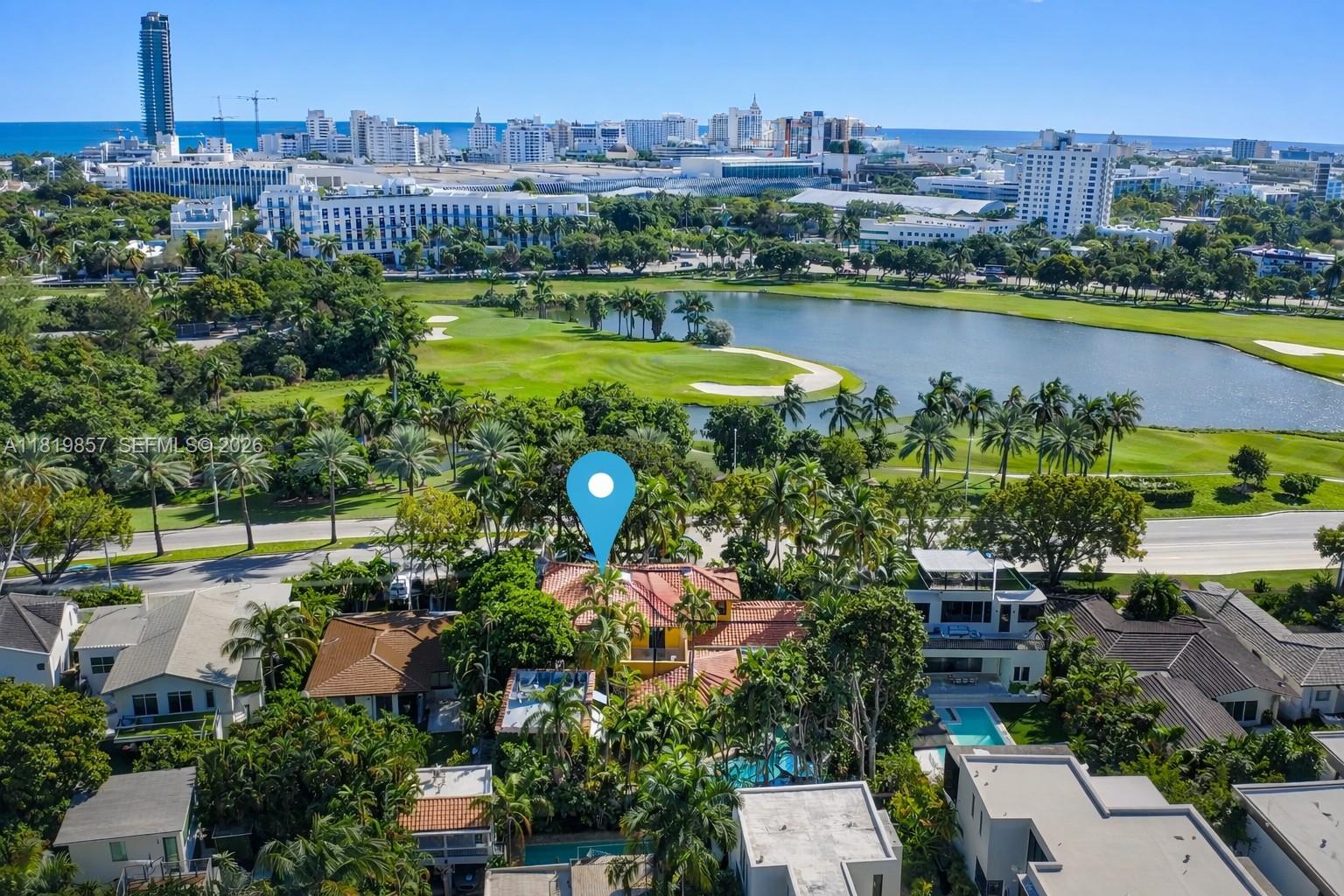 An aerial view shows a house with a red tile roof surrounded by lush trees — 2050 Alton Rd, Miami Beach FL 33140, MIAMI BEACH, FL