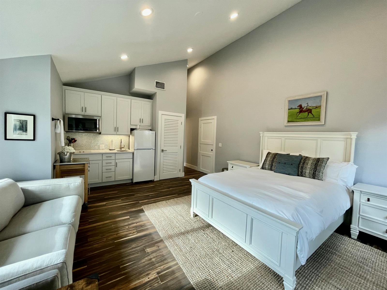 A studio apartment features a kitchenette, a white bed frame, and wood-look tile flooring — 11863 Wimbledon Circle # 547, Wellington FL 33414, WELLINGTON, FL