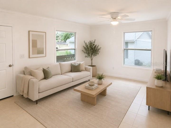 A bright living room features a beige sofa, wooden coffee table, and a ceiling fan — 1469 19TH STREET, SARASOTA, FL