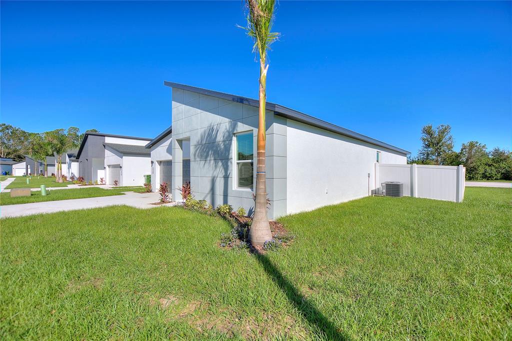 A modern, single-story white house with a slanted roof and a palm tree in front — 330 ROYAL PALM WAY, WINTER HAVEN, FL