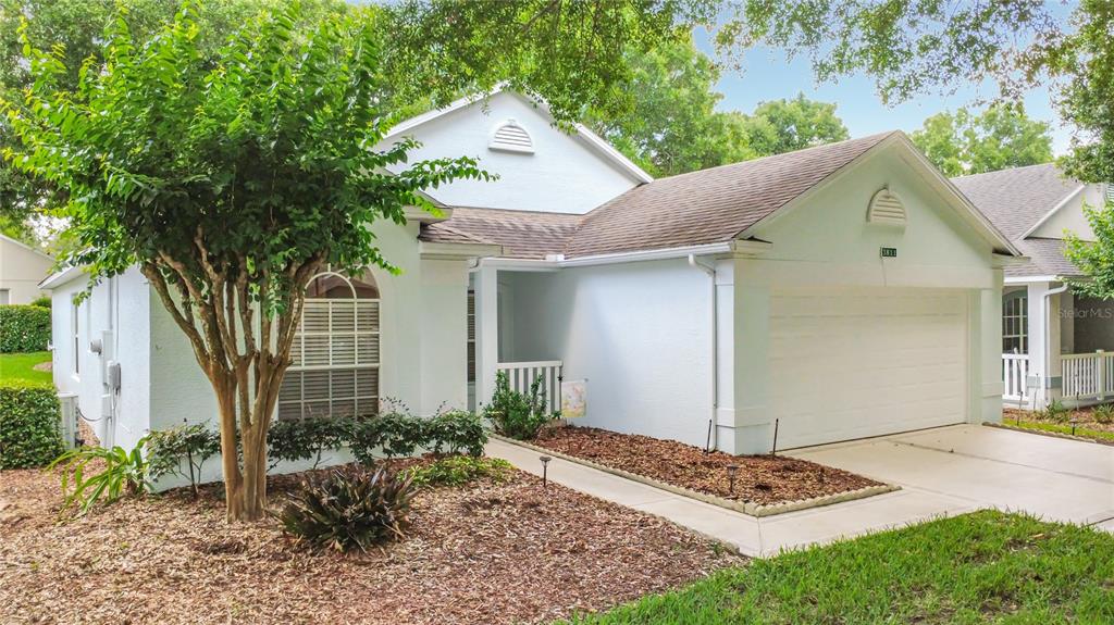 A light blue single-story house with a two-car garage and a landscaped front yard — 3811 WESTERHAM DRIVE, CLERMONT, FL