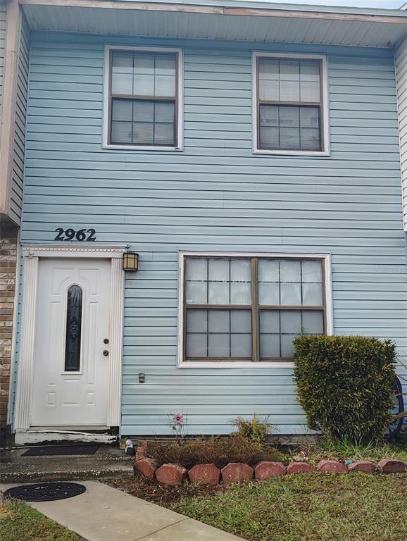 A two-story house with light blue siding, a white front door, and a front garden — 2962 MORGAN COMBEE ROAD, LAKELAND, FL