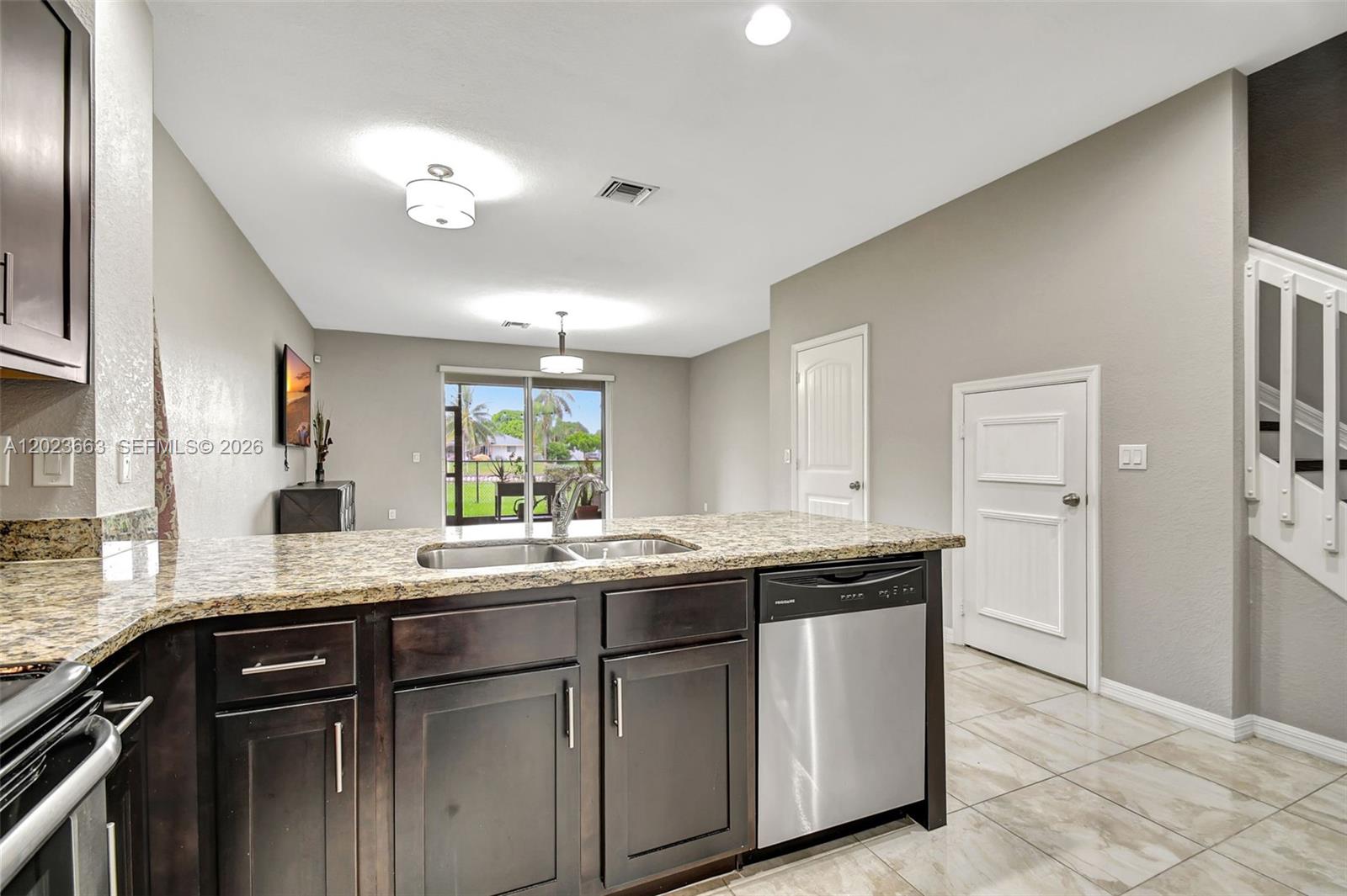 An entryway features a staircase, tiled floors, two green chairs, and a large abstract painting — 1119 Vermilion Dr, Lake Worth FL 33461, LAKE WORTH, FL