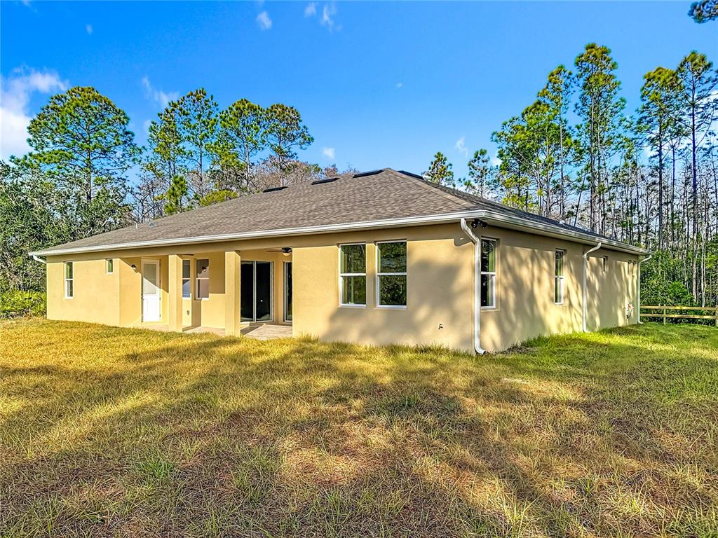 The exterior of a tan, single-story house features a hip roof and a grassy yard — 19022 MARDI GRAS STREET, ORLANDO, FL