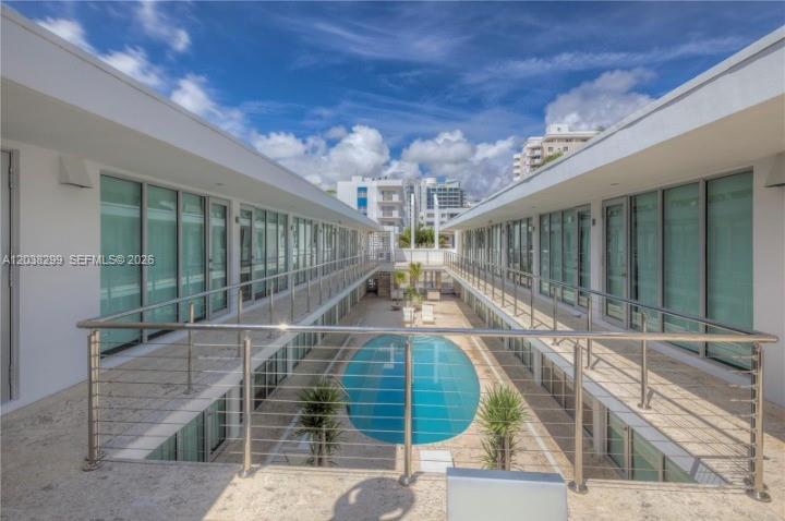 An elevated view of a swimming pool courtyard between two modern white apartment buildings — 1601 West Ave # 212, Miami Beach FL 33139, MIAMI BEACH, FL