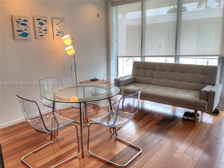 A dining area with a glass table and clear chairs sits beside a tufted sofa — 1601 West Ave # 212, Miami Beach FL 33139, MIAMI BEACH, FL