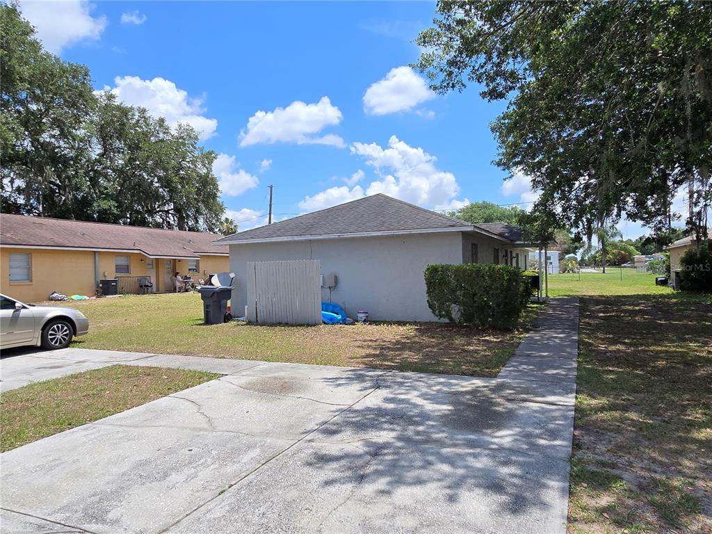 A gray house with a concrete driveway and a white privacy screen in the yard — 5667 STRUTHERS COURT, WINTER HAVEN, FL