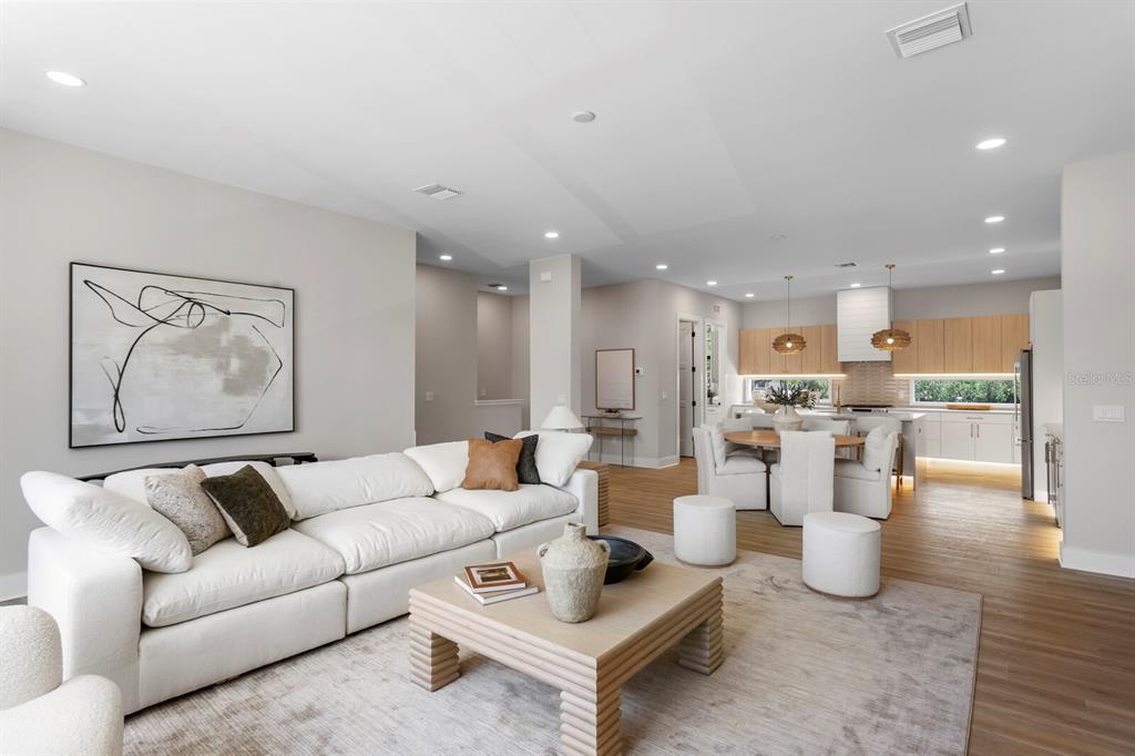 A bright, open-concept living room and dining area with light wood floors and modern decor — 5210 BAYSHORE BOULEVARD UNIT 4, TAMPA, FL