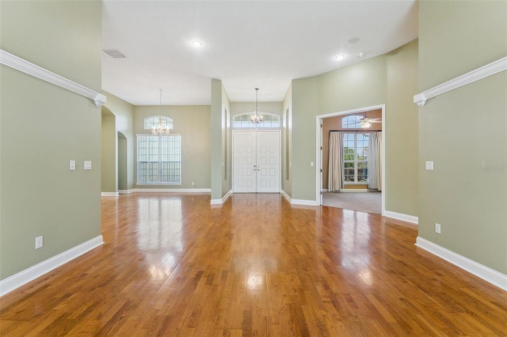 A spacious foyer with hardwood floors, sage green walls, and double front entry doors — 17540 VISTA BELLE COURT, MONTVERDE, FL