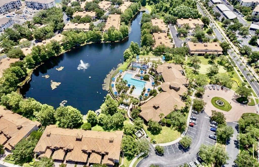 An aerial view shows a community swimming pool, playground, and clubhouse with a parking lot — 142 GLASGOW COURT, DAVENPORT, FL