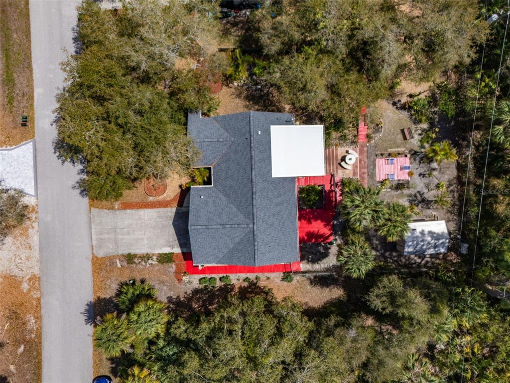 An aerial view shows a house with a dark shingled roof and a white patio cover — 16235 BANYAN AVENUE, PORT CHARLOTTE, FL