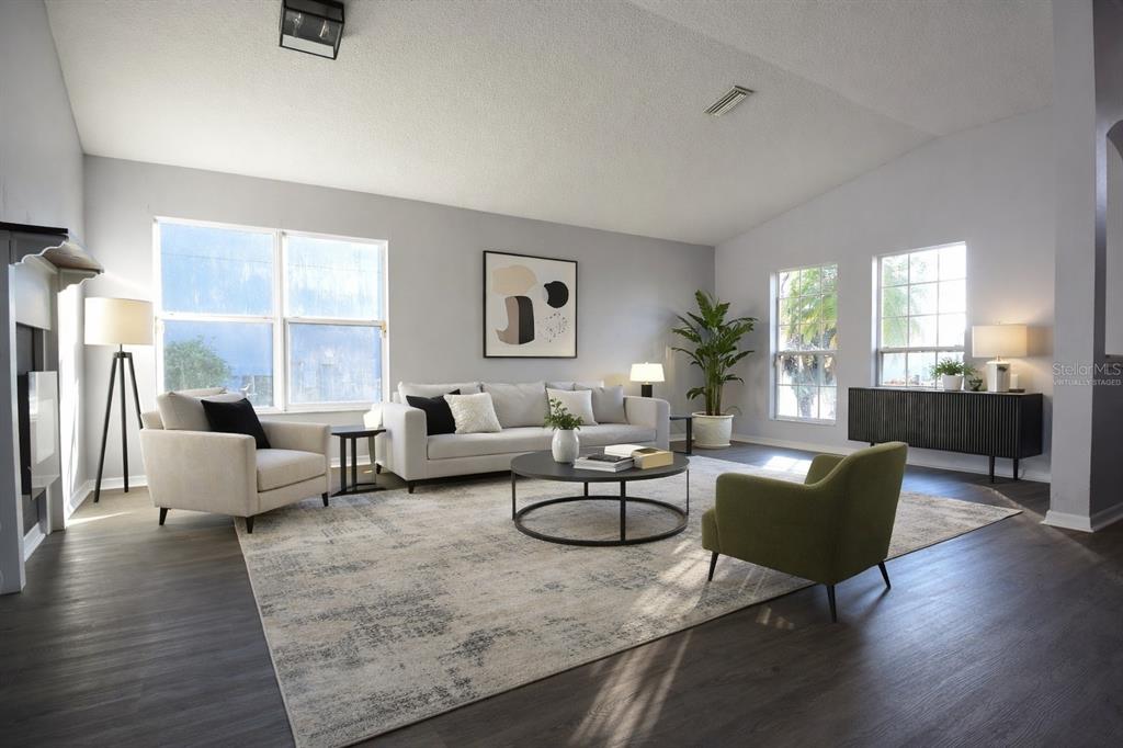 A living room with light gray walls, dark wood flooring, and neutral-toned furniture — 11454 WALDEN LOOP, PARRISH, FL