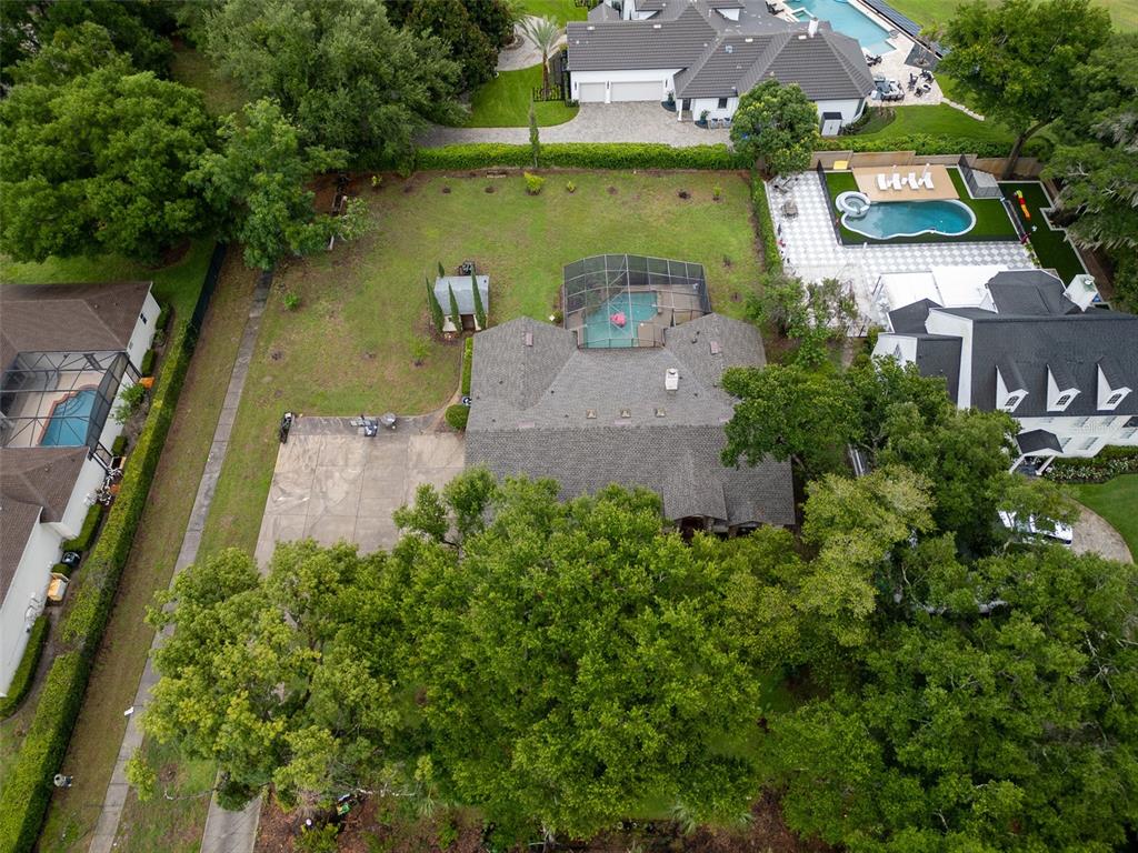 A side view of a house exterior featuring a garage, brick accents, and a lawn — 1407 HEMPEL AVENUE, WINDERMERE, FL