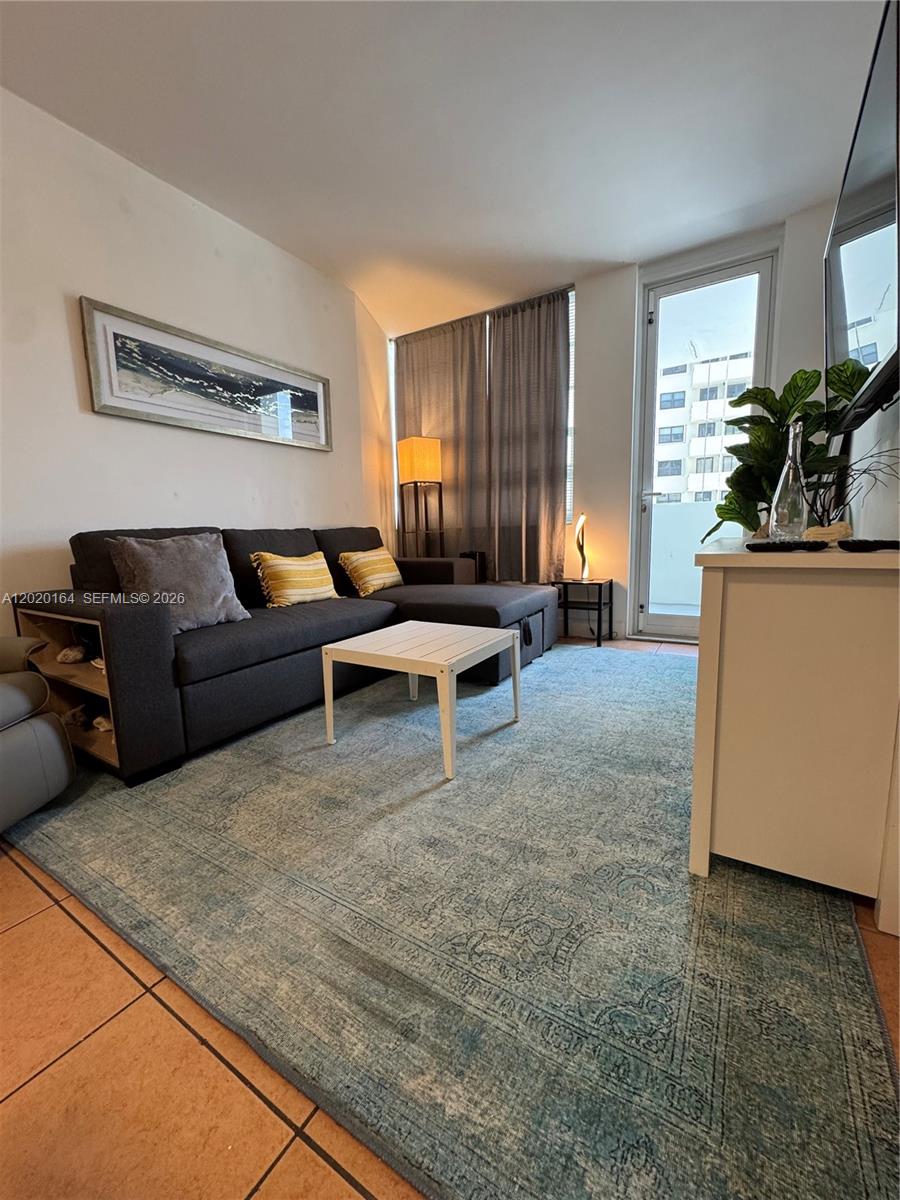 A living room features a dark sectional sofa, a white coffee table, and a rug — 100 Lincoln Rd # 303, Miami Beach FL 33139, MIAMI BEACH, FL
