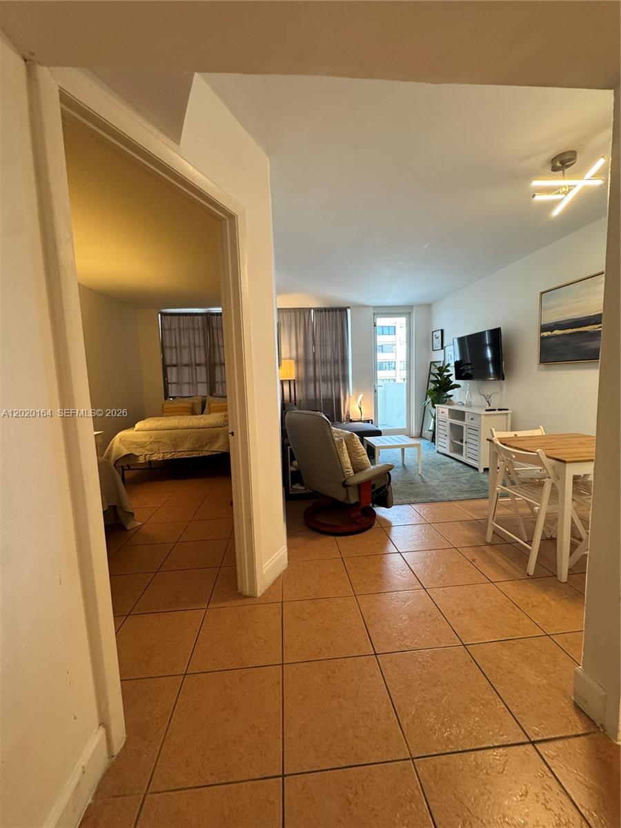 A view from a tiled hallway into a living room and an adjacent bedroom — 100 Lincoln Rd # 303, Miami Beach FL 33139, MIAMI BEACH, FL