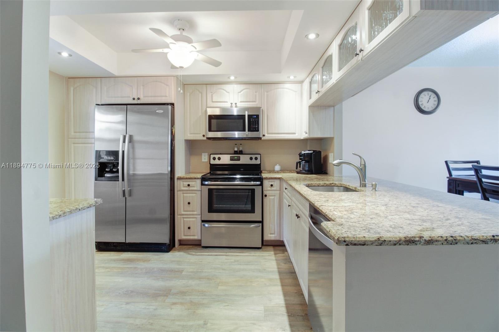 A kitchen features light-colored cabinetry, stainless steel appliances, and granite countertops — 605 Oaks Dr # 305, Pompano Beach FL 33069, POMPANO BEACH, FL