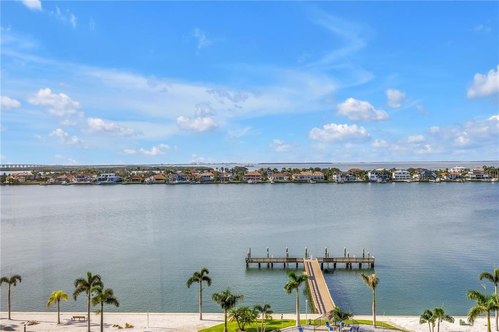 An elevated view of a calm bay with a wooden pier and distant waterfront houses — 5108 BRITTANY DRIVE S UNIT 908, ST PETERSBURG, FL