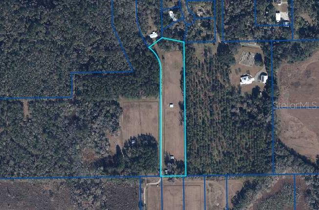 This is an aerial map showing a long, rectangular plot of land outlined in blue — TBD NW 71ST TERRACE, GAINESVILLE, FL