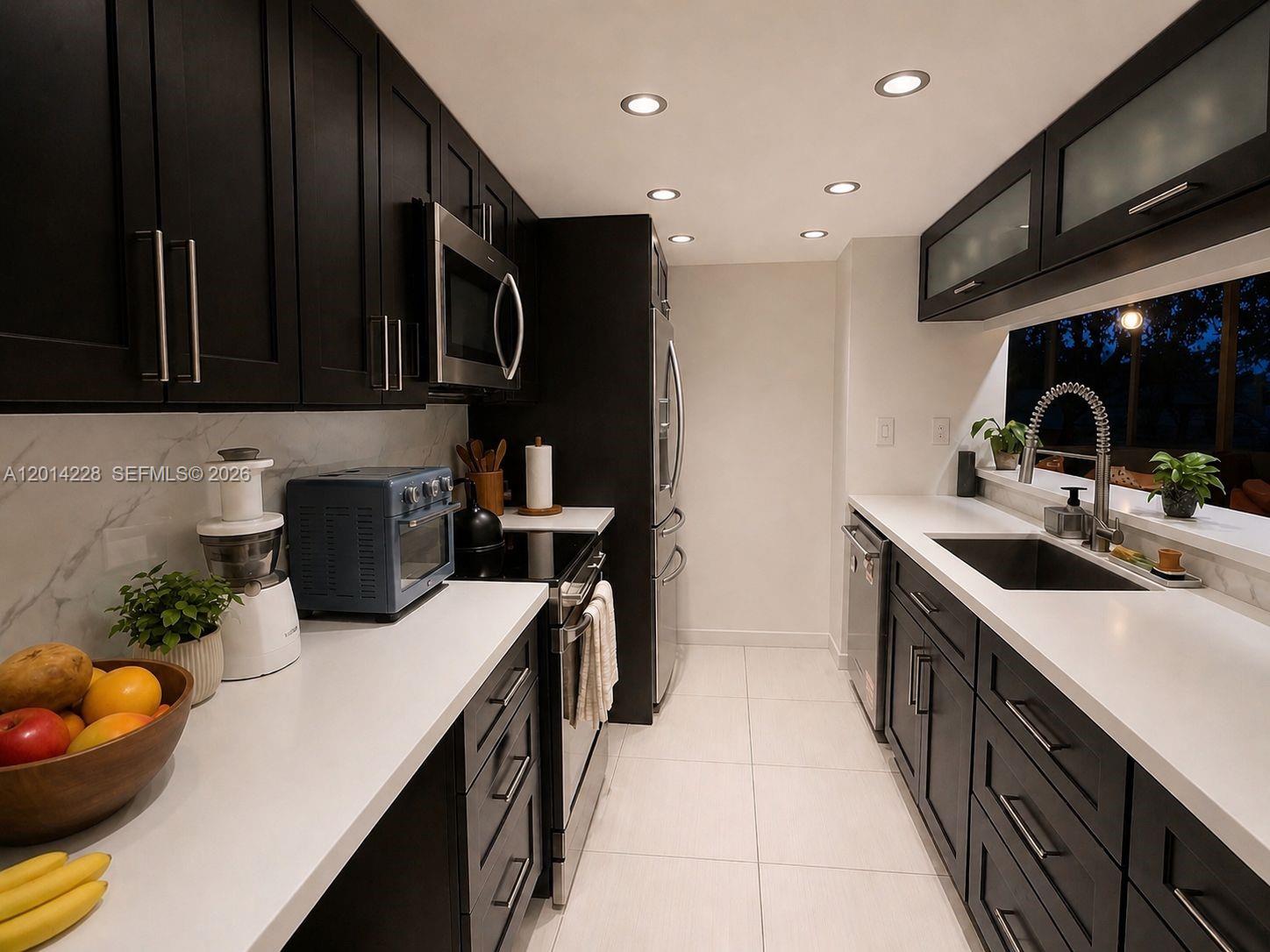 A modern galley kitchen features dark cabinets, white countertops, stainless steel appliances, and recessed lighting — 21075 NE 34th Ave # 2, Aventura FL 33180, AVENTURA, FL
