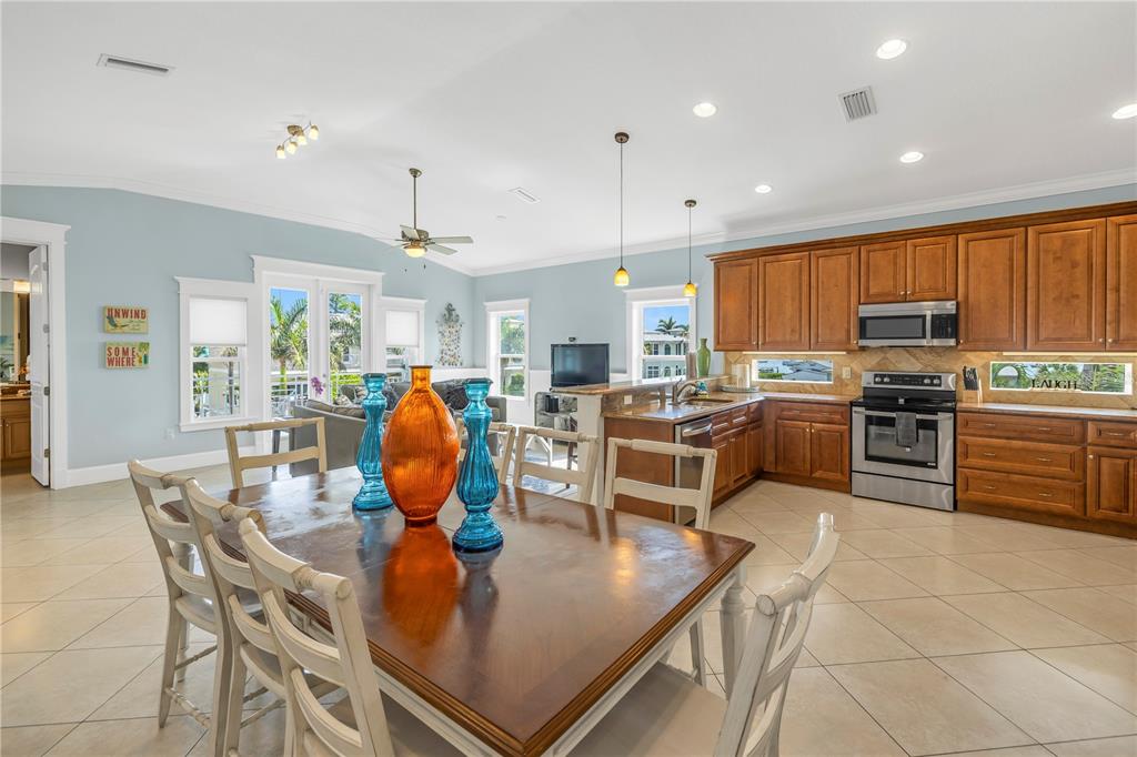 A dining area with a wooden table sits in front of an open-concept kitchen — 105 4TH STREET S, BRADENTON BEACH, FL