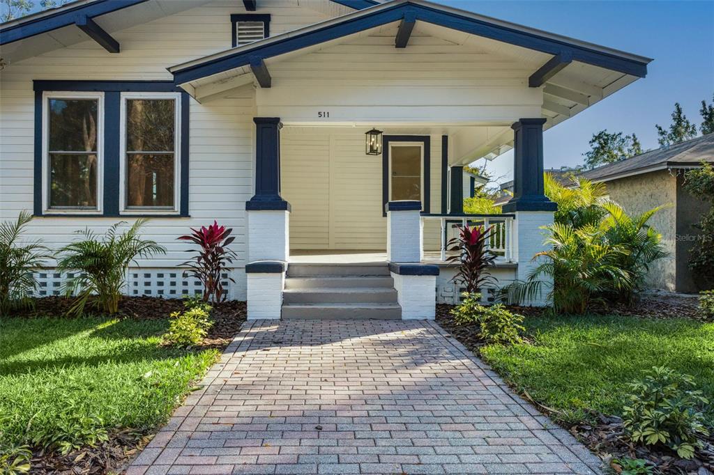 A white bungalow with blue trim features a brick walkway leading to a front porch — 511 E FRANCES AVENUE, TAMPA, FL