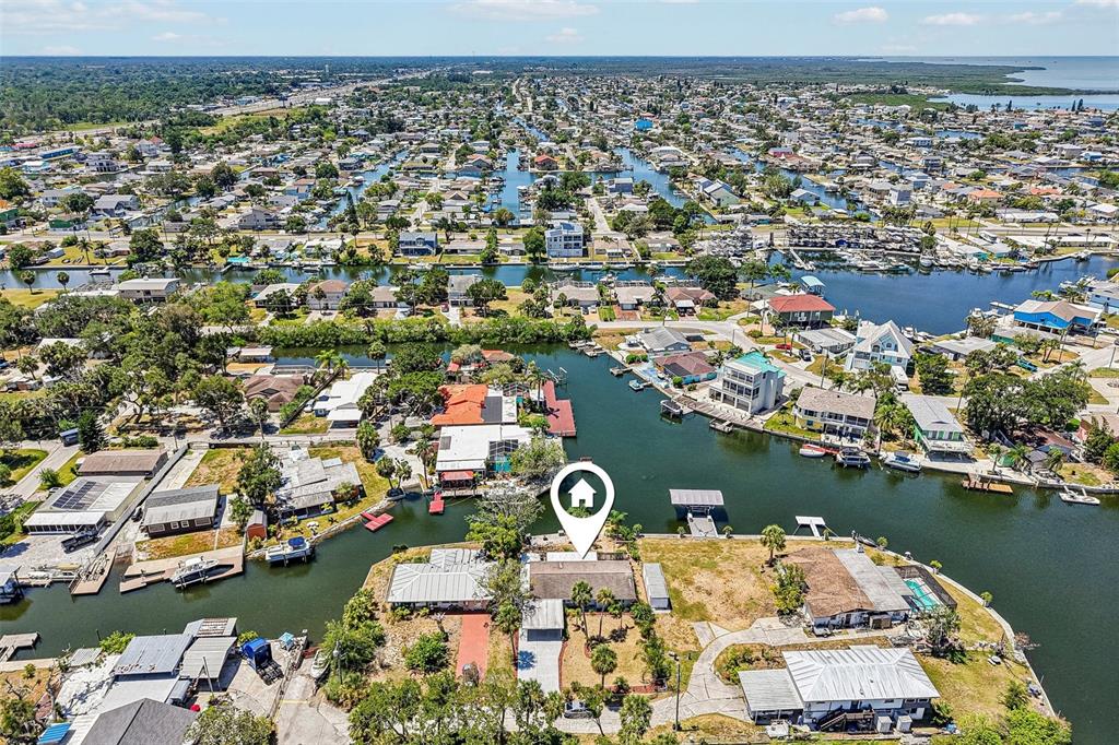 An aerial view shows a waterfront house with a boat dock on a canal — 14124 KULIG COURT, HUDSON, FL