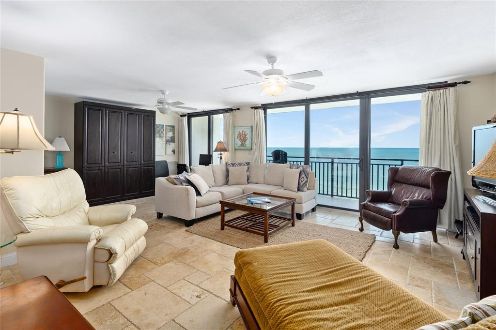 A living room with tile floors, a sectional sofa, and a balcony overlooking the ocean — 4139 S. ATLANTIC AVENUE UNIT B504, NEW SMYRNA BEACH, FL