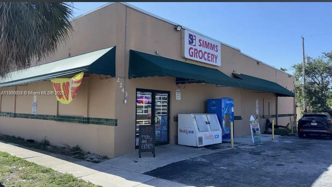 The exterior of a single-story commercial building with a green awning and signage — 2243 Simms St, Hollywood FL 33020, HOLLYWOOD, FL