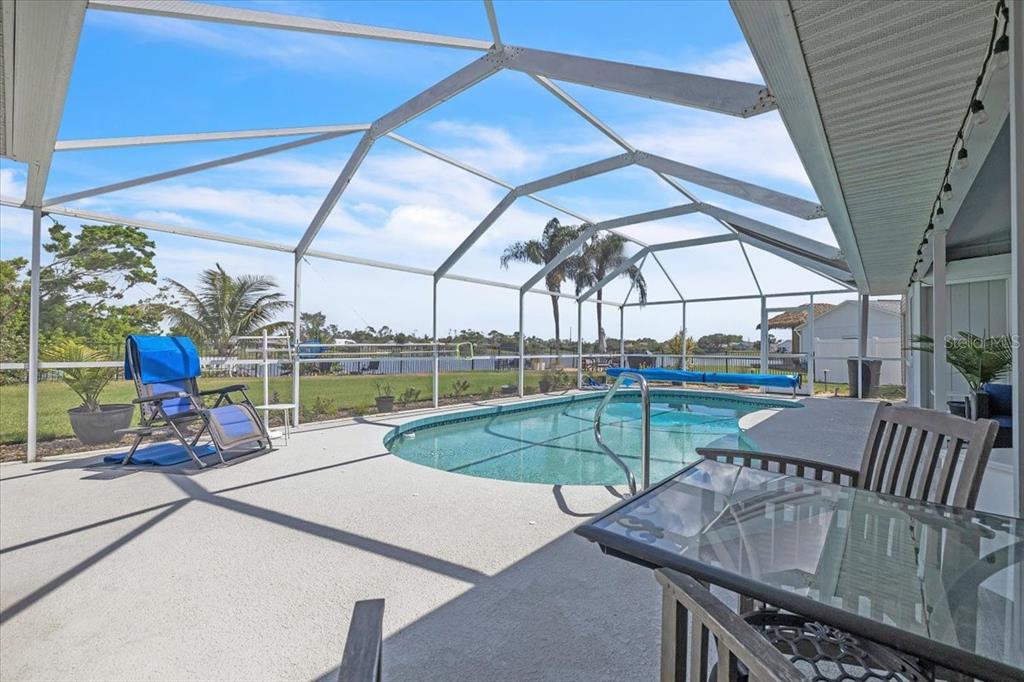 A screened-in patio features a swimming pool, outdoor furniture, and a view of the yard — 6308 ZENO CIRCLE, PORT CHARLOTTE, FL