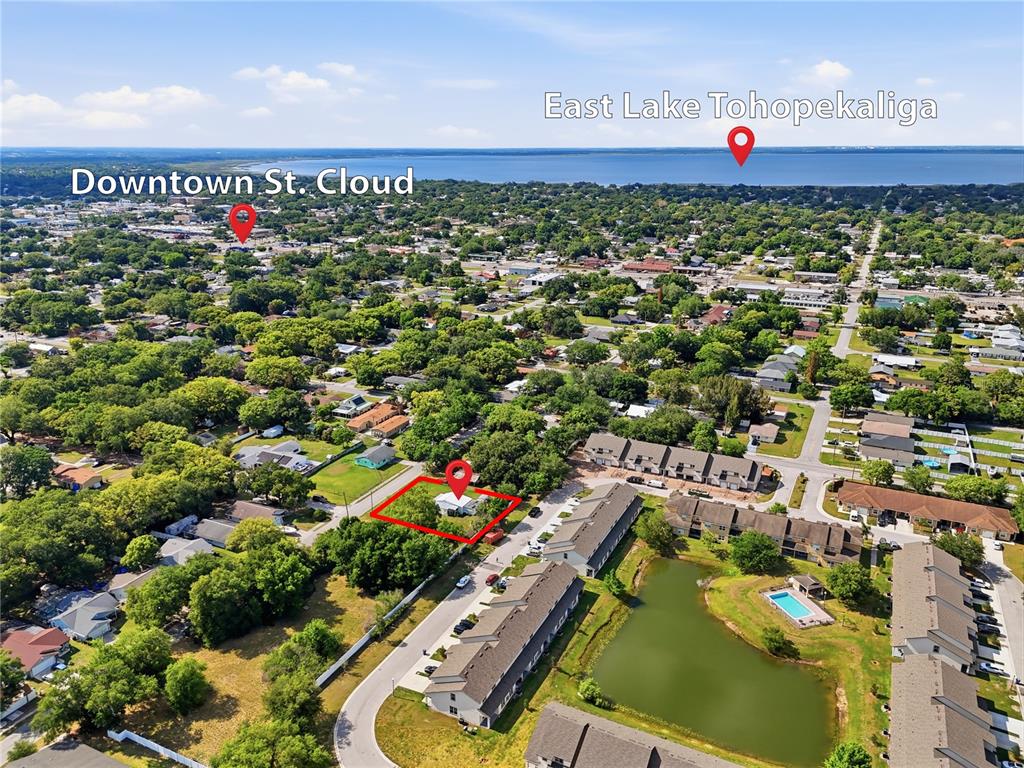 This aerial view shows a residential lot highlighted in red near a lake and town — 1705 DELAWARE AVENUE, ST CLOUD, FL