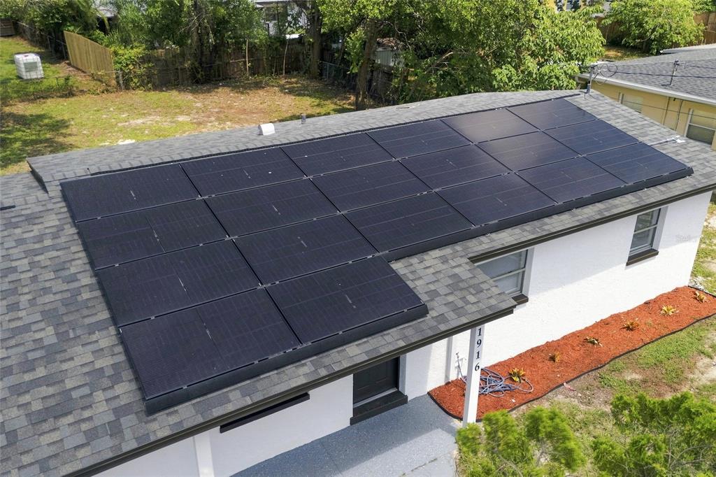 An aerial view of a residential roof featuring a large array of black solar panels — 1916 MARVY AVENUE, TAMPA, FL