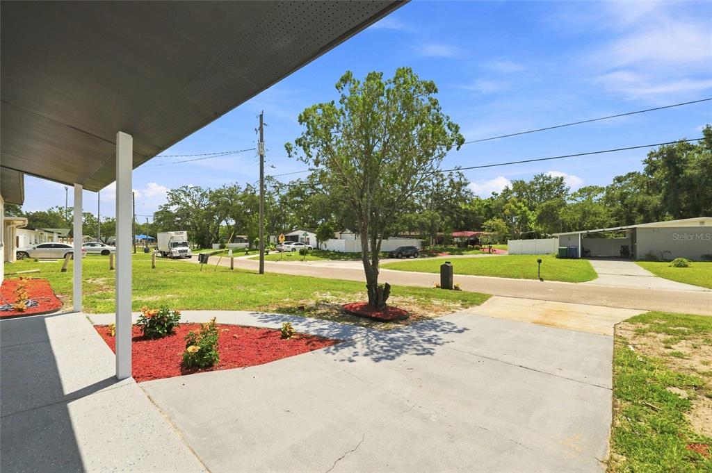 A view from a covered porch looking out toward a residential street and front yard — 1916 MARVY AVENUE, TAMPA, FL