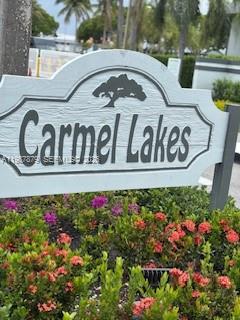 A white sign with the text Carmel Lakes stands above a bed of flowering shrubs — 468 NE 206th Ln # 107, Miami FL 33179, MIAMI, FL