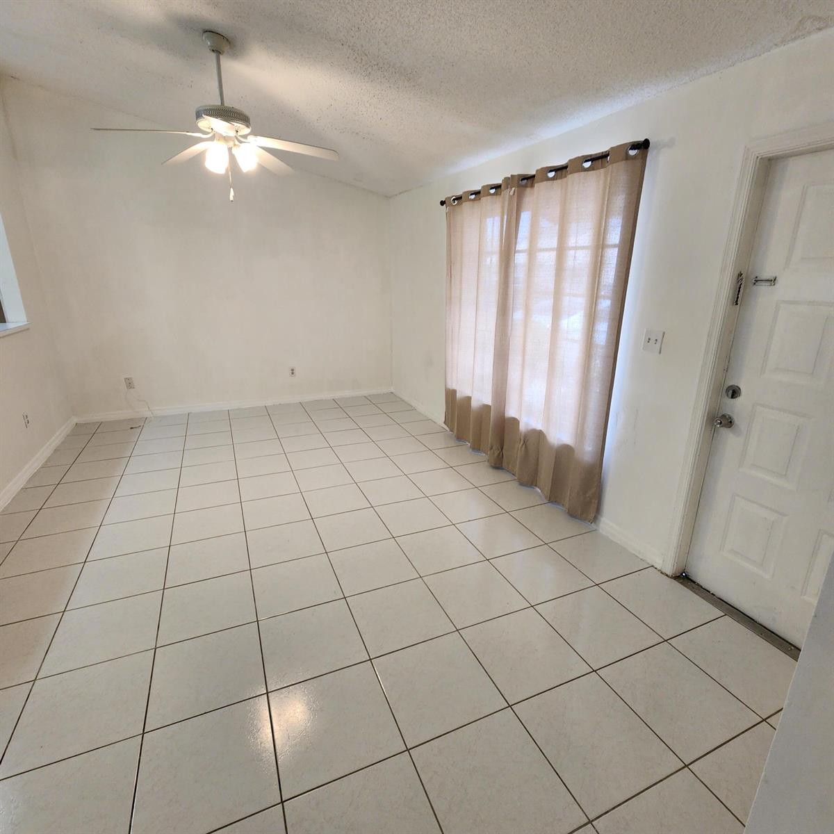 A kitchen with a breakfast bar opens into a living area with white tile floors — 500 NE 3rd Street # 109, FL 33009, FL