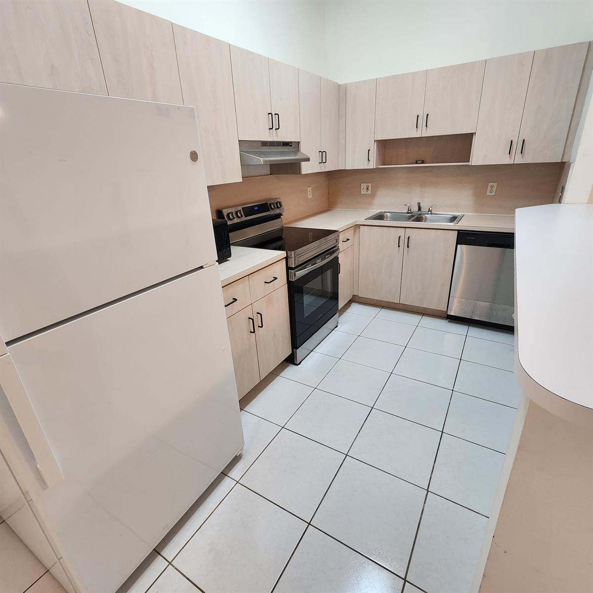 An empty room features white walls, a ceiling fan, light-colored tile flooring, and brown curtains — 500 NE 3rd Street # 109, FL 33009, FL