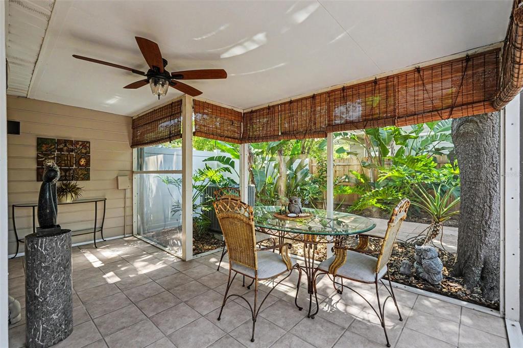 A screened-in porch features tile flooring, a ceiling fan, and a glass-top dining set — 3053 S CONCORDIA AVENUE UNIT A, TAMPA, FL