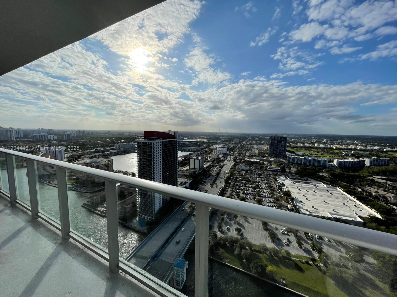 A high-angle view from a balcony overlooking a city, a waterway, and a highway — 4010 S Ocean Dr # R3306, Hollywood FL 33019, HOLLYWOOD, FL