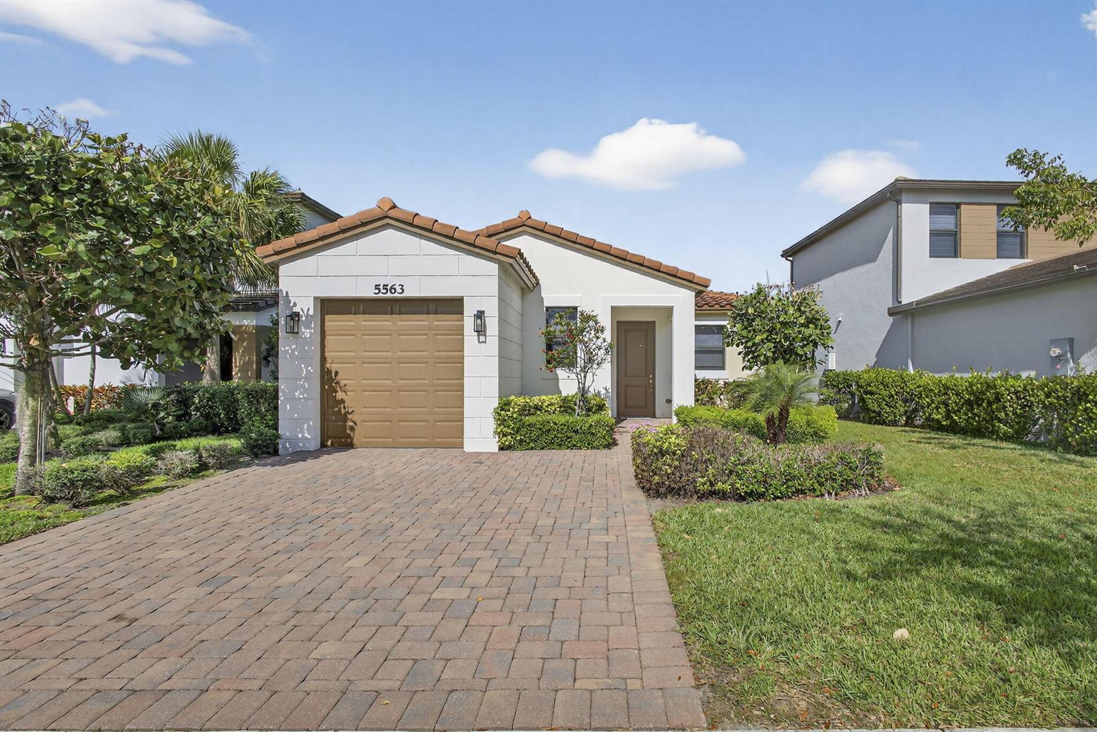 A single-story house with a paved driveway, a one-car garage, and a tiled roof — 5563 Starfish Road, Westlake FL 33470, WESTLAKE, FL