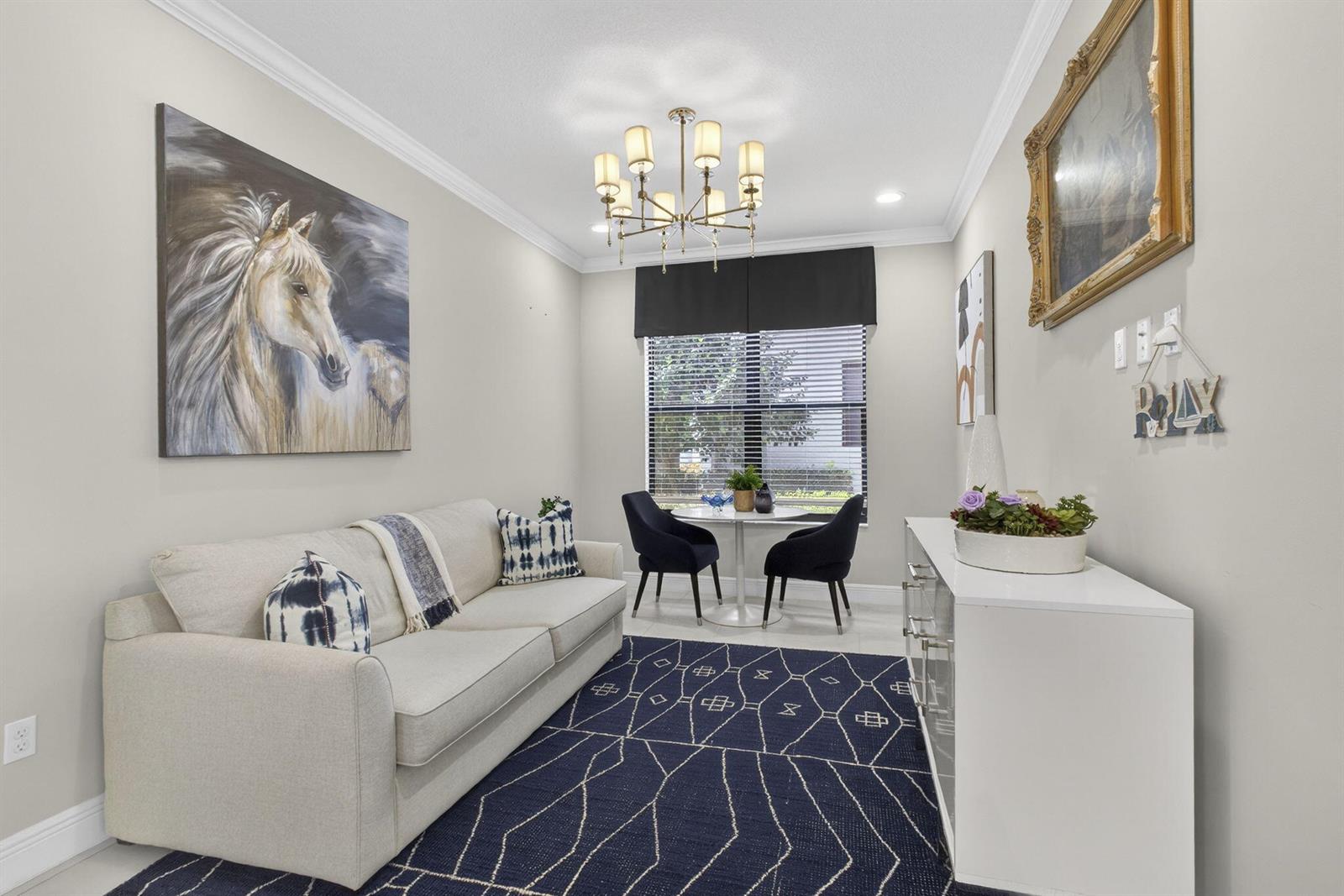 A living room features a beige sofa, a dark blue patterned rug, and a dining area — 5563 Starfish Road, Westlake FL 33470, WESTLAKE, FL