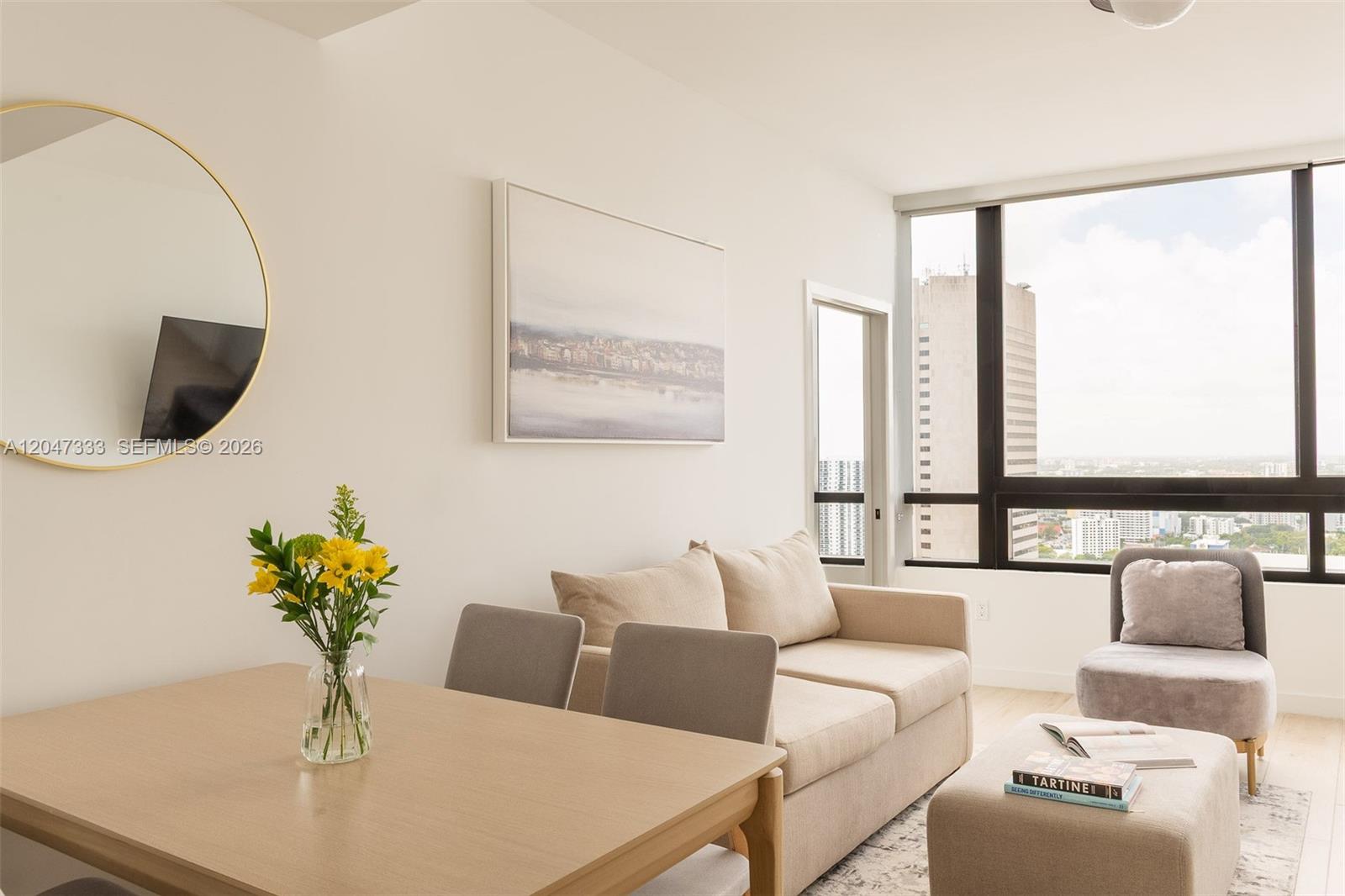 A modern living and dining area features a beige sofa, light wood table, and floor-to-ceiling windows — 225 N Miami Ave # 3412, Miami FL 33128, MIAMI, FL