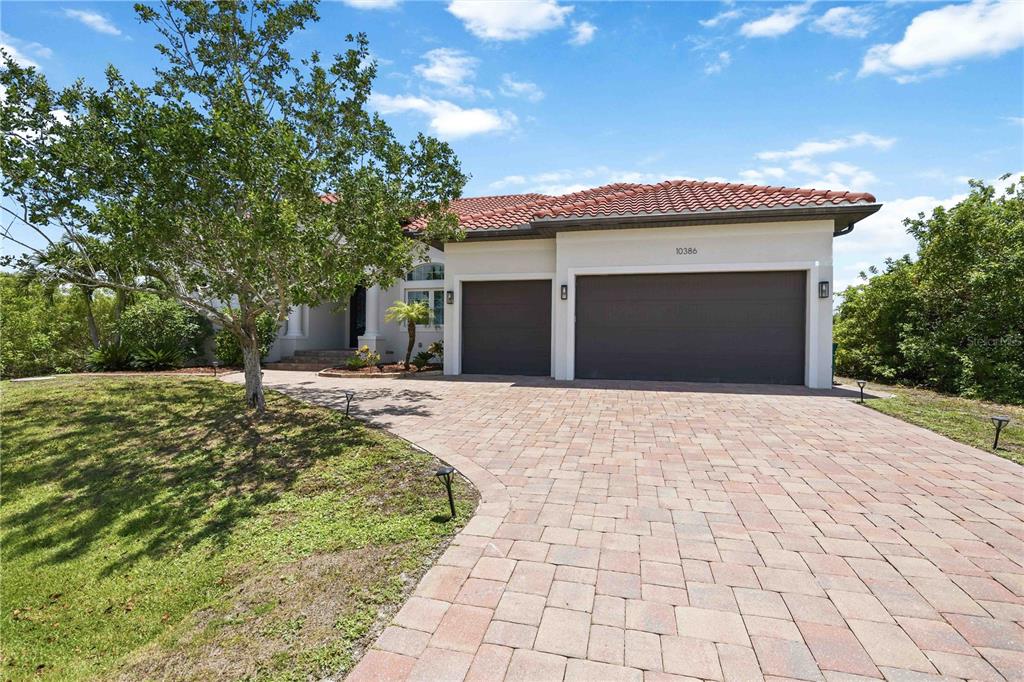 A single-story house with a tiled roof, a three-car garage, and a paved driveway — 10386 WINNIPEG STREET, PORT CHARLOTTE, FL