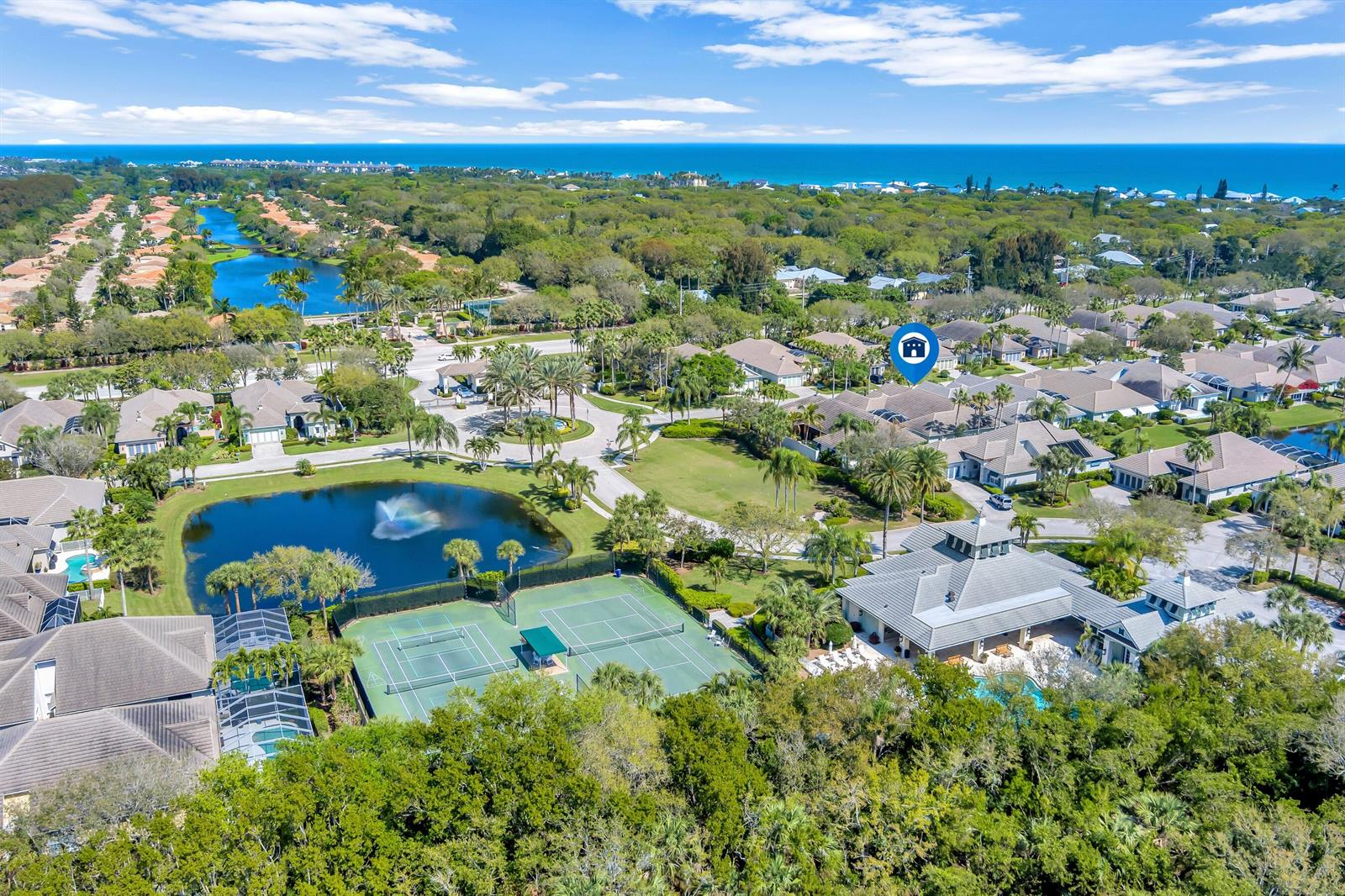 An aerial view shows a residential community with a lake, tennis courts, and a clubhouse — VERO BEACH, FL