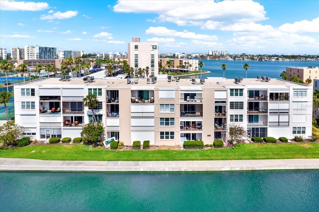 An aerial view of a multi-story apartment building situated along a waterfront — 7625 SUN ISLAND DRIVE S UNIT 304, SOUTH PASADENA, FL