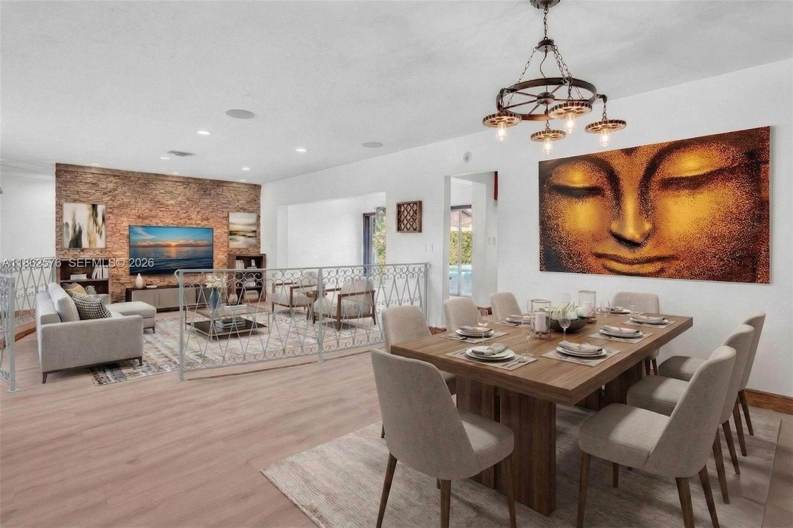 An open-concept dining and living area features a stone accent wall and a large Buddha painting — 20350 Highland Lakes Blvd, Miami FL 33179, MIAMI, FL