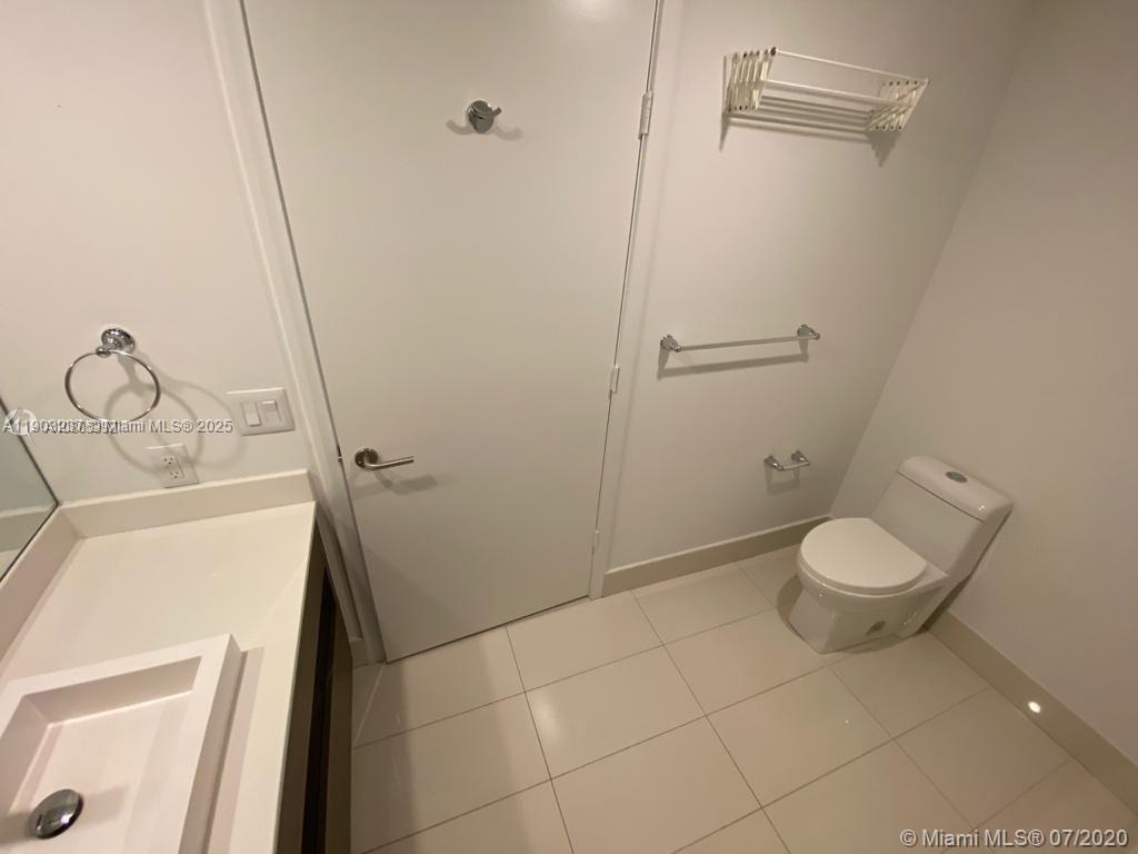 A bathroom features a white vanity, a toilet, and a wall-mounted towel rack — 1100 S MIAMI AVE # 3011, Miami FL 33130, MIAMI, FL