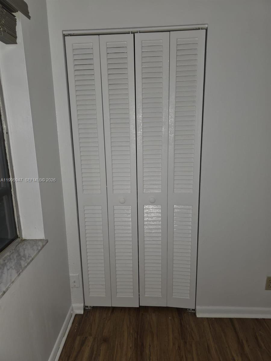 A white louvered bifold closet door is installed in a room with light-colored walls — 13731 Flora Pl # A, Delray Beach FL 33484, DELRAY BEACH, FL