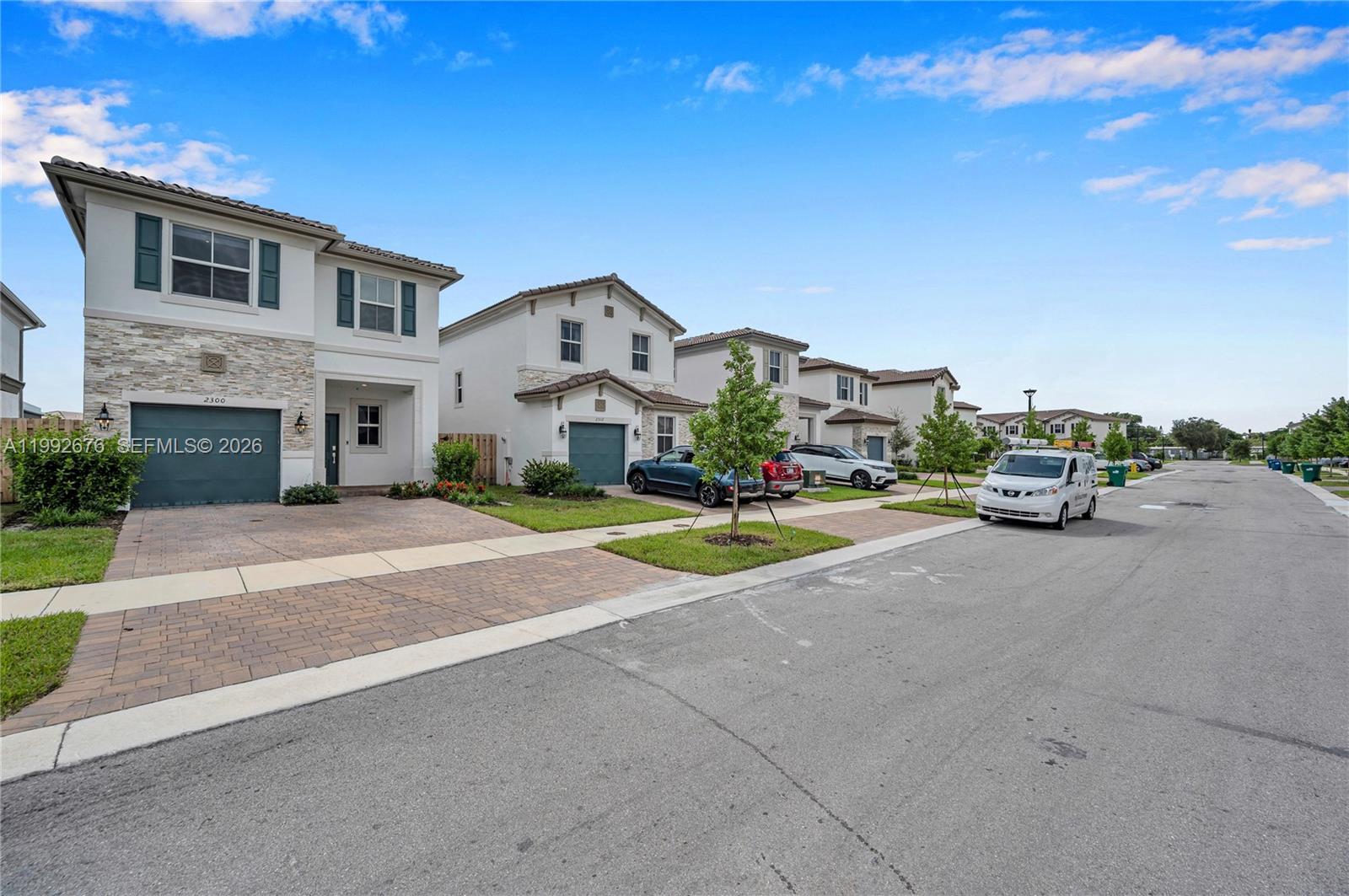A street view shows a row of modern two-story suburban houses with paved driveways — 2300 NW 130th St, Miami FL 33167, MIAMI, FL