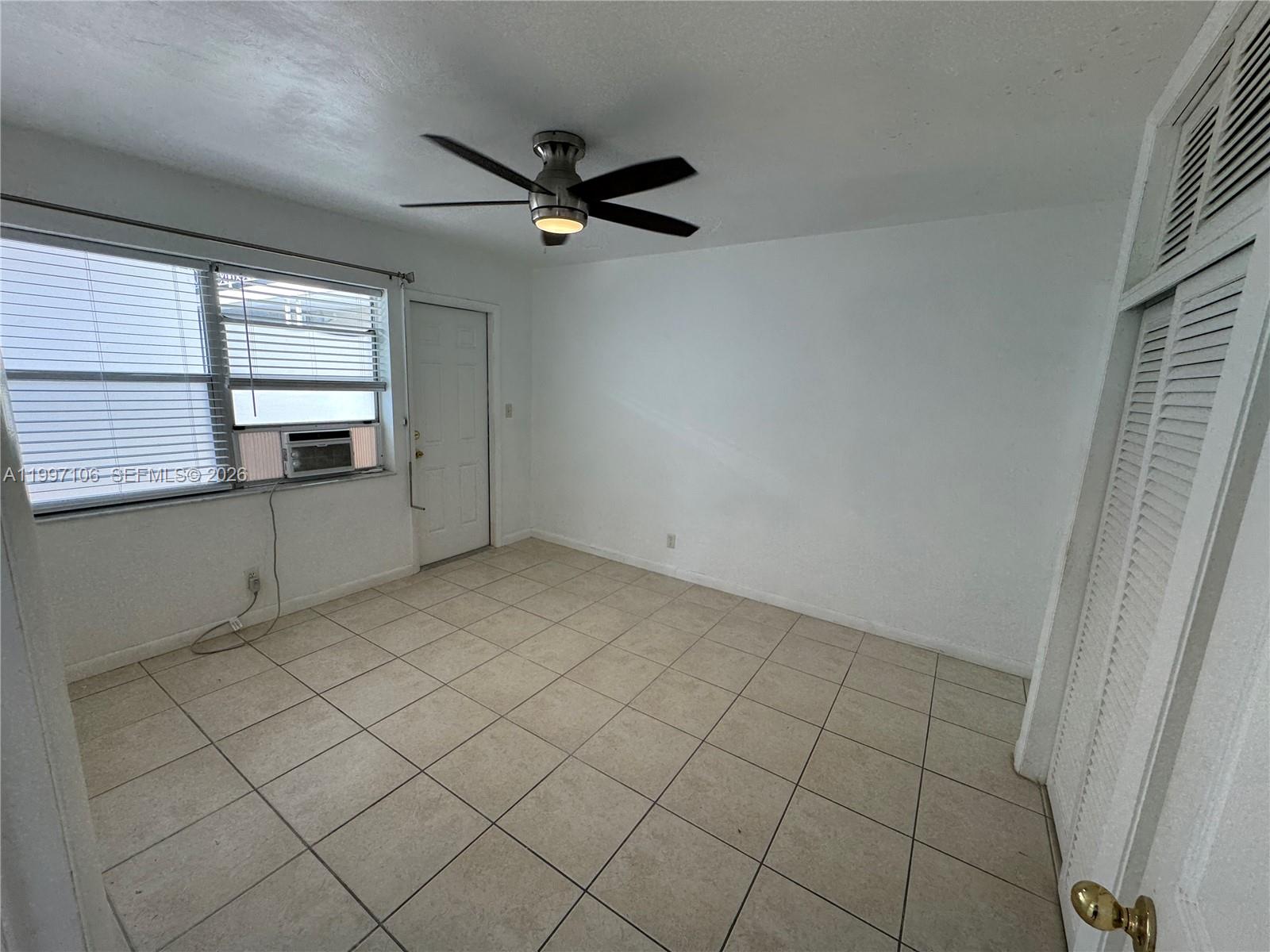 A room with white walls, tiled floors, a ceiling fan, and a window air conditioner — 2000 Buchanan St # 11, Hollywood FL 33020, HOLLYWOOD, FL
