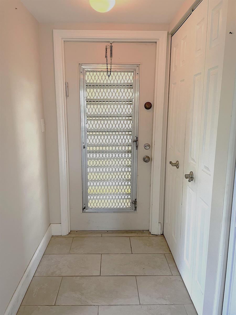 An entryway features a white door with a metal security screen and tiled flooring — 367 S Federal Highway # C426, Deerfield Beach FL 33441, DEERFIELD BEACH, FL