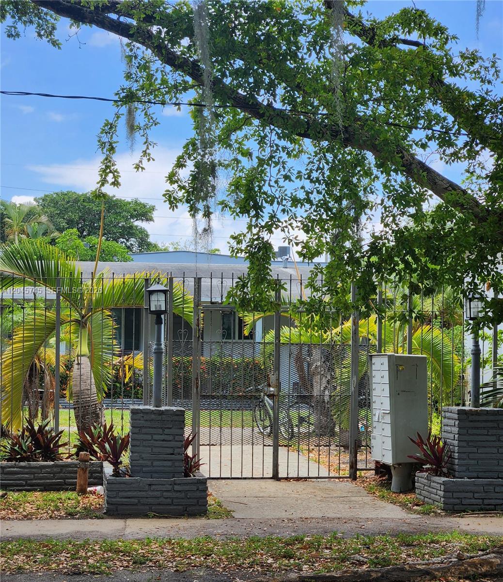 A gated entrance with brick pillars and a metal fence leads to a residential property — 2000 Washington St, Hollywood FL 33020, HOLLYWOOD, FL